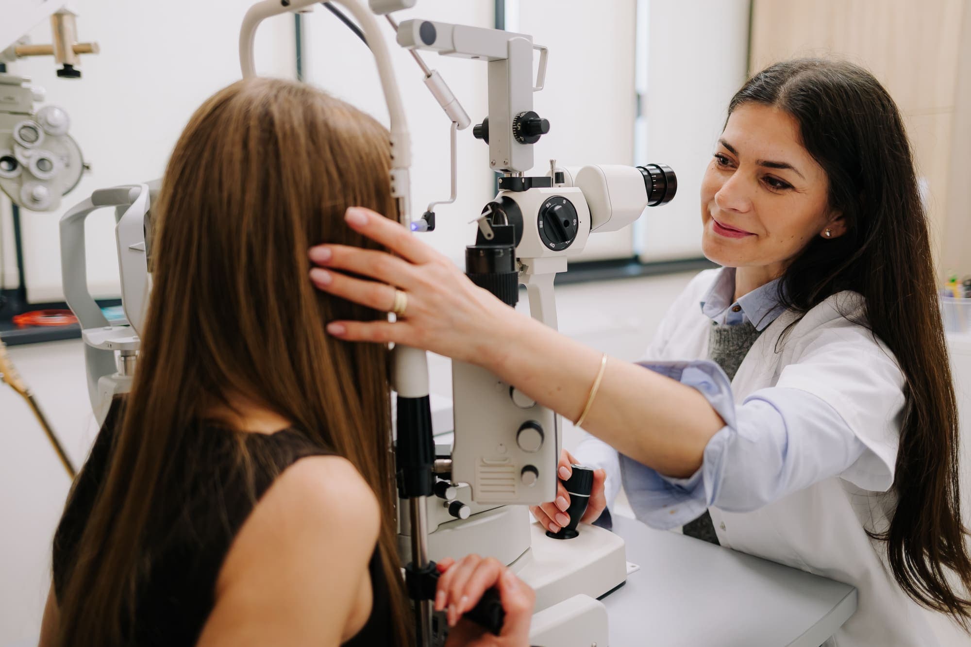 Medic oftalmolog Platinum Optic examinând o pacientă la biomicroscop